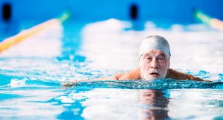 Senior man swimming in lap lane